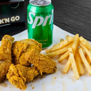 A plate of fried chicken and french fries with a drink.