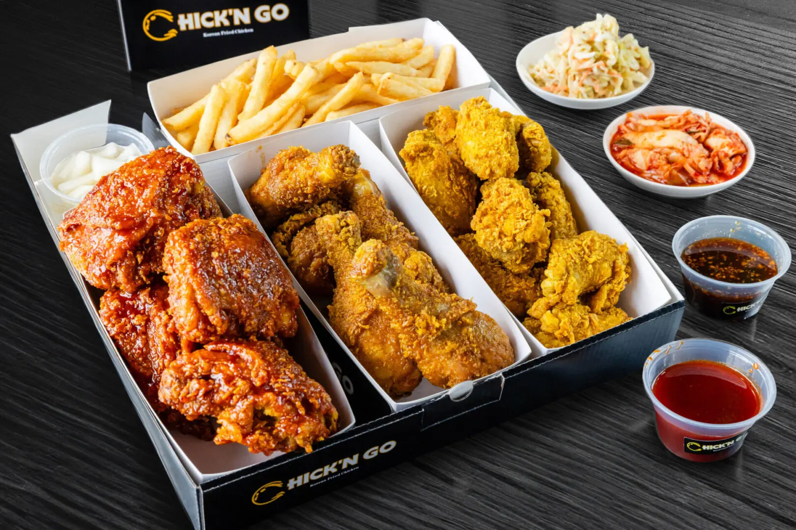 A box of fried chicken and fries with sides.
