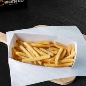 A box of fries on top of a wooden board.