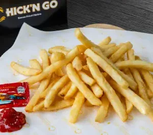 A plate of french fries on top of a table.