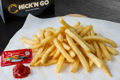 A plate of french fries on top of a table.