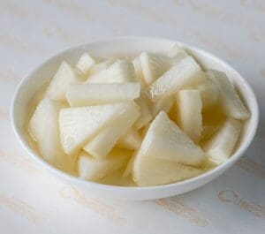 A bowl of sliced apples on top of the table.