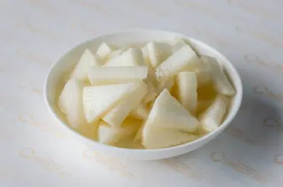 A bowl of sliced apples on top of the table.