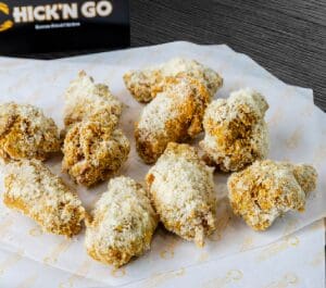 A plate of chicken covered in parmesan cheese.